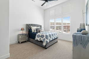 Carpeted bedroom featuring baseboards and a ceiling fan