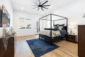 Bedroom with light wood-style floors, ceiling fan, access to exterior, and recessed lighting