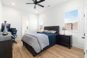 Bedroom with light wood-style floors, recessed lighting, a desk, connected bathroom, and ceiling fan