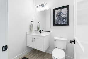 Half bathroom with vanity and wood finished floors
