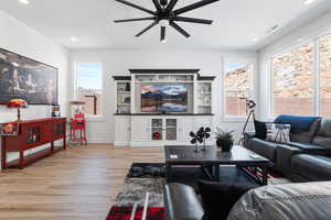 Living room featuring a ceiling fan, healthy amount of natural light, light wood-type flooring, and recessed lighting