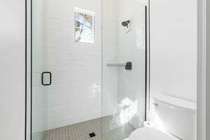 Full bath featuring toilet and a shower stall