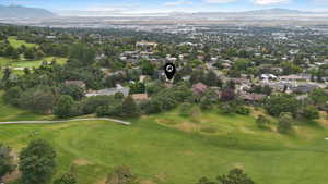Aerial perspective of suburban area with a mountain backdrop and a local golf course