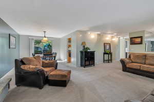 Living room with rail lighting and light colored carpet