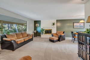 Living area featuring light carpet and a brick fireplace