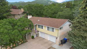 Aerial view of property and surrounding area featuring a mountain backdrop