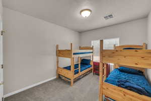 Carpeted bedroom with baseboards and a textured ceiling