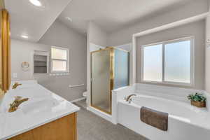 Bathroom featuring a garden tub, a stall shower, double vanity, plenty of natural light, and recessed lighting