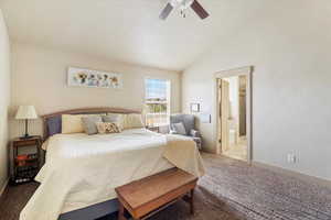 Bedroom with carpet flooring, lofted ceiling, connected bathroom, a ceiling fan, and a textured ceiling