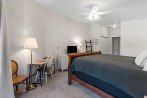 Carpeted bedroom with a closet and a ceiling fan