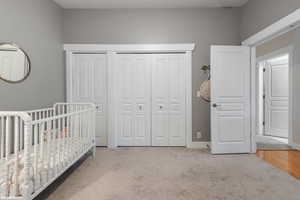 Bedroom featuring carpet floors and a crib