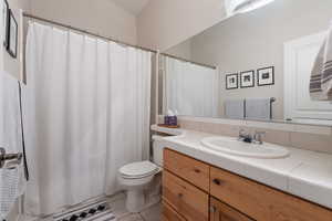 Full bath featuring vanity, tile patterned flooring, and curtained shower