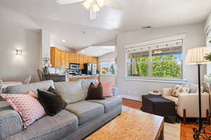 Living room with light wood-style floors, lofted ceiling, ceiling fan, and recessed lighting
