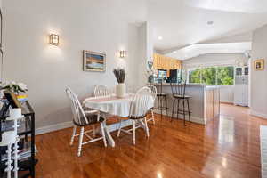 Dining space with lofted ceiling, light wood-type flooring, and recessed lighting