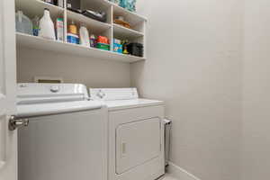 Laundry room with washer and dryer and a textured wall