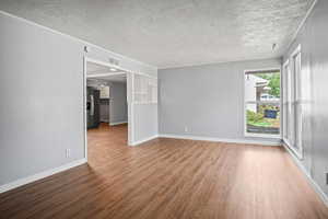Spare room featuring wood finished floors and a textured ceiling