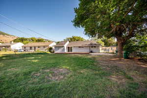 Back of property featuring a fenced backyard and a deck with mountain view