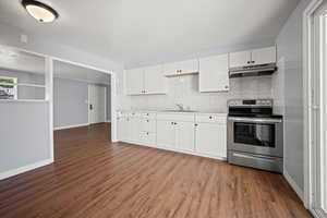 Kitchen with stainless steel range with electric stovetop, under cabinet range hood, backsplash, and dark wood finished floors