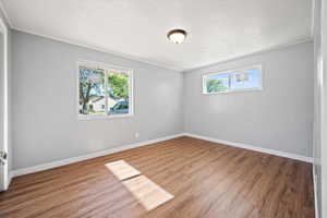 Empty room with wood finished floors and a textured ceiling