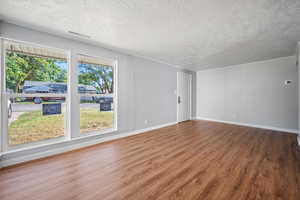 Spare room with a textured ceiling and wood finished floors