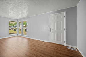 Unfurnished room featuring a textured ceiling and wood finished floors