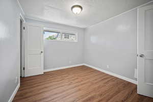 Empty room featuring a textured ceiling and wood finished floors