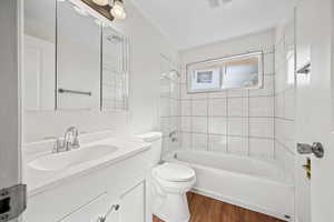 Bathroom with wood finished floors, vanity, and shower / bath combination
