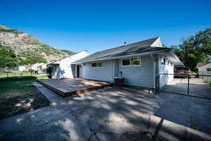 Rear view of house featuring a deck with mountain view and roof with shingles