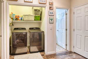 Washroom featuring separate washer and dryer and wood finished floors