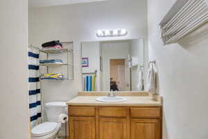 Full bath featuring vanity, curtained shower, and a textured wall