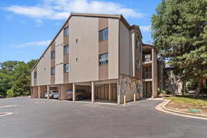 View of building exterior featuring covered parking