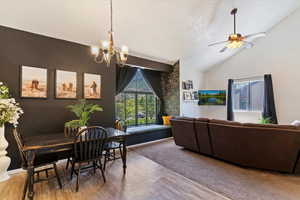 Dining room with a chandelier, lofted ceiling, a textured ceiling, wood finished floors, and ceiling fan
