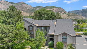 View of front of house with roof with shingles, a mountain view, and stone siding