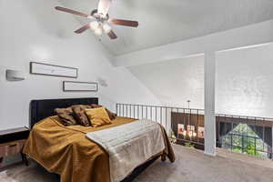 Bedroom featuring carpet, vaulted ceiling, a textured ceiling, and a ceiling fan