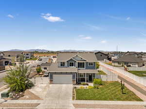 View of front of home featuring a residential view, concrete driveway, a gate, a mountain view, and a garage