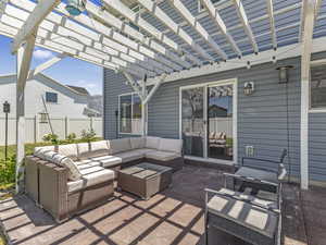 View of patio featuring outdoor lounge area and a large pergola.