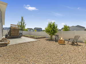 Fenced backyard featuring a patio area, an outdoor fire pit, and a residential view