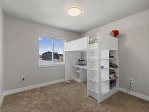 Bedroom with light colored carpet and baseboards