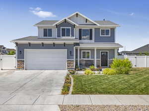 Craftsman-style house featuring RV parking, covered porch, 2 car garage and mature landscaping.