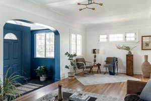 Living room featuring arched walkways, wood finished floors, and a chandelier