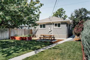 Rear view of property featuring brick siding and roof with shingles