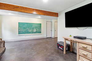 Living room featuring finished concrete flooring and baseboards