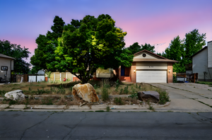 View of front of home featuring brick siding, driveway, and a garage