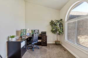 Carpeted home office featuring baseboards