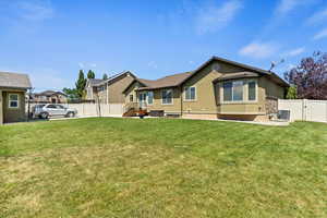 Back of house with stucco siding, a fenced backyard, and a gate