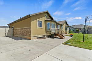 View of property exterior with stucco siding, stone siding, a gate, and a patio