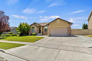 View of front facade featuring a gate, concrete driveway, a garage, stucco siding, and stone siding