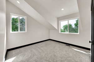 Bonus room with carpet, healthy amount of natural light, recessed lighting, and vaulted ceiling