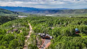 Bird's eye view of a mountain backdrop and a heavily wooded area