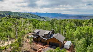 View of subject property featuring a heavily wooded area and a mountainous background